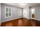 Bedroom featuring two shuttered windows and entry into the bathroom on wood floors at 4916 Gathering Pl, Suwanee, GA 30024