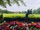 Common area with colorful flowers and shrubs, statue, gazebo, and sprawling green space at 4916 Gathering Pl, Suwanee, GA 30024