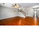 Open-concept living room with hardwood floors, ceiling fan, and staircase at 4916 Gathering Pl, Suwanee, GA 30024