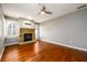Bright living room features a stone fireplace, hardwood floors, and a ceiling fan at 4916 Gathering Pl, Suwanee, GA 30024