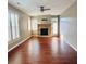 Bright living room features a stone fireplace, hardwood floors, and plantation shutters at 4916 Gathering Pl, Suwanee, GA 30024