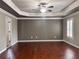Primary bedroom features hardwood floors, tray ceiling, and plantation shutters at 4916 Gathering Pl, Suwanee, GA 30024
