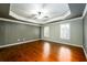 Primary bedroom features hardwood floors, tray ceiling, ceiling fan, and plantation shutters at 4916 Gathering Pl, Suwanee, GA 30024