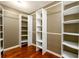 A spacious walk-in closet with adjustable shelving and ample storage space on a wood floor at 4916 Gathering Pl, Suwanee, GA 30024