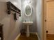 Cozy powder room with pedestal sink, decorative shelving, and wood-look floors for style and convenience at 111 Bexley Ln, Douglasville, GA 30134