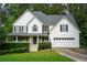 Charming two-story home with white siding, black shutters, a well-manicured lawn, and attached two car garage at 111 Bexley Ln, Douglasville, GA 30134