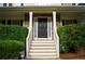 Front door flanked by sidelights and stone accents, enhanced with manicured hedges at 111 Bexley Ln, Douglasville, GA 30134