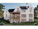 This two-story home showcases a charming rear exterior with a covered porch, balcony, and pristine lawn at 405 Cynthia Ln, Mcdonough, GA 30252