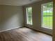 Bright bedroom with light-colored walls and vinyl plank flooring featuring two large windows at 7593 Watson Bay Ct, Stone Mountain, GA 30087
