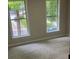 Bright and airy bedroom with plush carpeting and large windows overlooking green space at 7593 Watson Bay Ct, Stone Mountain, GA 30087