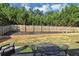 Backyard featuring lush lawn, wooden fence, and outdoor seating area at 109 Rockefeller Ln, Dallas, GA 30157