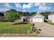 Inviting exterior view of a home showcasing its manicured lawn, mature tree, and a two-car garage at 109 Rockefeller Ln, Dallas, GA 30157