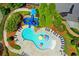 A vibrant community pool with a water slide and colorful umbrellas surrounded by lush landscaping and lounge chairs at 4495 Hedgewood Dr, Cumming, GA 30041
