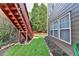 View of the backyard with stairway to the deck, showing green grass and mature trees at 4495 Hedgewood Dr, Cumming, GA 30041