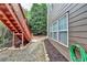 View of the house from the backyard with stairs to the upper deck and mulch landscaping at 4495 Hedgewood Dr, Cumming, GA 30041