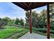 View of the shady backyard from a covered patio with wood supports and a lawn at 4495 Hedgewood Dr, Cumming, GA 30041