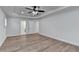 A bedroom with light wood flooring, a ceiling fan, and two doors on the back wall at 4495 Hedgewood Dr, Cumming, GA 30041