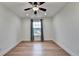 Bright bedroom featuring a ceiling fan, wood floors, and a window with gray curtains at 4495 Hedgewood Dr, Cumming, GA 30041