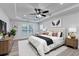 Bright bedroom with tray ceiling, ceiling fan, and light wood floors, with a bed and decorations at 4495 Hedgewood Dr, Cumming, GA 30041