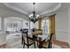 Open concept dining room with modern chandelier, hardwood floors, and view into living room at 4495 Hedgewood Dr, Cumming, GA 30041