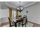 Charming dining room with tray ceiling, modern chandelier, and natural light from the window at 4495 Hedgewood Dr, Cumming, GA 30041