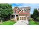 Beautiful two-story home with brown siding, a landscaped yard, a basketball hoop, and an attached garage at 4495 Hedgewood Dr, Cumming, GA 30041