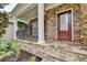 Close-up view of the front porch with stone accents and a red front door at 4495 Hedgewood Dr, Cumming, GA 30041