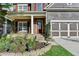 Inviting front porch with stone accents, a well-manicured garden bed, and an attached two-car garage at 4495 Hedgewood Dr, Cumming, GA 30041