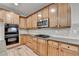 Well-equipped kitchen featuring wood cabinets, granite counters, stainless steel appliances and tiled backsplash at 4495 Hedgewood Dr, Cumming, GA 30041