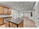 Kitchen island with granite counters and wood cabinets open to a sunlit living area at 4495 Hedgewood Dr, Cumming, GA 30041