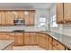 Stylish kitchen with wood cabinets, granite counters, tiled backsplash and stainless steel appliances at 4495 Hedgewood Dr, Cumming, GA 30041