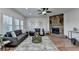 Inviting living room featuring hardwood floors, stone fireplace, bright windows, and a ceiling fan at 4495 Hedgewood Dr, Cumming, GA 30041