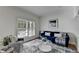 Bright living room with white plantation shutters, a blue sofa, and a modern glass coffee table at 4495 Hedgewood Dr, Cumming, GA 30041