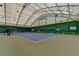 Interior shot of a tennis court with a high, arched ceiling and well-maintained surface at 4495 Hedgewood Dr, Cumming, GA 30041