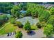 Aerial view of tennis courts surrounded by mature trees and landscaping near a parking lot and green space at 4495 Hedgewood Dr, Cumming, GA 30041