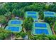 Aerial view of six tennis courts with blue and green surfaces surrounded by lush greenery at 4495 Hedgewood Dr, Cumming, GA 30041