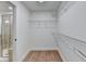 Spacious walk-in closet with wire shelving and hardwood floors adjacent to the bathroom at 4495 Hedgewood Dr, Cumming, GA 30041