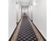 Long hallway featuring plush carpet runner with decorative pattern and classic white walls at 1105 Pine Heights Ne Dr, Atlanta, GA 30324