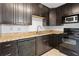 This kitchen features sleek black appliances, granite countertops, and dark brown cabinetry for a modern feel at 1105 Pine Heights Ne Dr, Atlanta, GA 30324