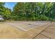 Outdoor tennis court surrounded by mature trees at 1105 Pine Heights Ne Dr, Atlanta, GA 30324