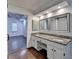 Bathroom with double vanity, granite counters, and mirrors. Bedroom is visible from doorway at 2530 Ashbourne Dr, Lawrenceville, GA 30043