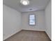 Empty bedroom with neutral carpeting and window overlooking the back yard at 2530 Ashbourne Dr, Lawrenceville, GA 30043