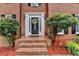 Elegant front entryway with a decorative wreath, sidelights and mature landscaping at 2530 Ashbourne Dr, Lawrenceville, GA 30043