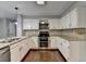 Modern kitchen with stainless steel appliances, granite countertops, and white cabinets at 2530 Ashbourne Dr, Lawrenceville, GA 30043