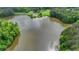 An aerial view of a serene lake surrounded by green trees with a gazebo on a small island at 2530 Ashbourne Dr, Lawrenceville, GA 30043