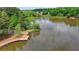 A lake with a boat launch and a small dock surrounded by green trees in a quiet neighborhood at 2530 Ashbourne Dr, Lawrenceville, GA 30043
