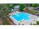 A bright blue community pool with lounge chairs, umbrellas, and a bath house amongst mature trees at 2530 Ashbourne Dr, Lawrenceville, GA 30043