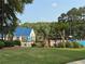 Community pool area with blue roofed clubhouse, mature landscaping, and ample seating at 2530 Ashbourne Dr, Lawrenceville, GA 30043