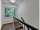 Second floor landing with hardwood floors, staircase with black metal railing, and large windows with nature view at 2530 Ashbourne Dr, Lawrenceville, GA 30043