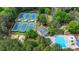 An aerial view of a community with tennis courts, a pool and clubhouse surrounded by nature at 2530 Ashbourne Dr, Lawrenceville, GA 30043